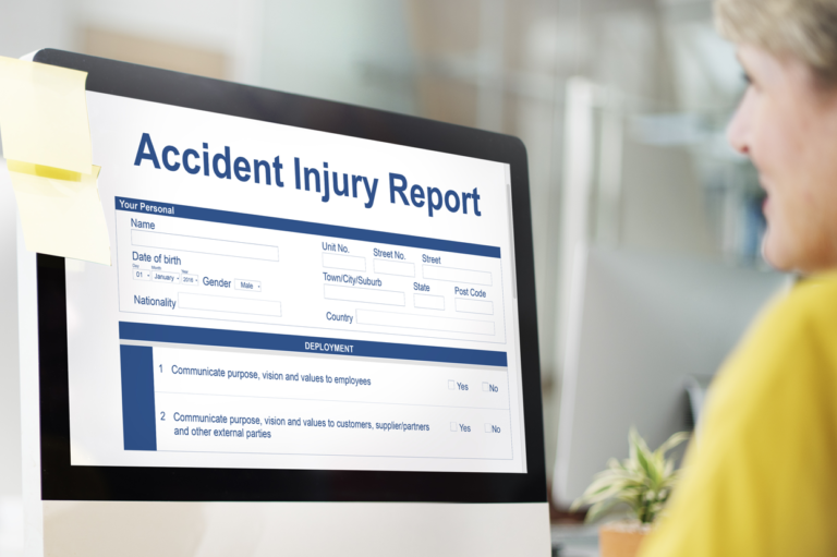 A person looking at a screen of an accident injury report. Learn to avoid common mistakes when reporting work injuries.