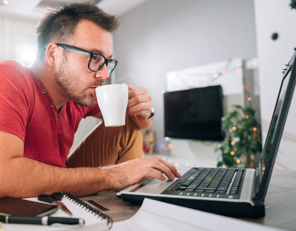 Person working from home with coffee cup in hand