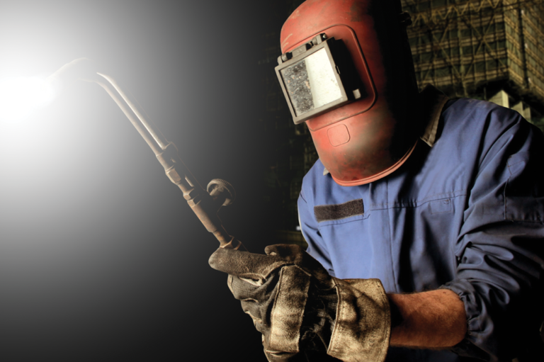 A welder in protective gear. Read about protecting yourself from ear damage caused by hot slag.