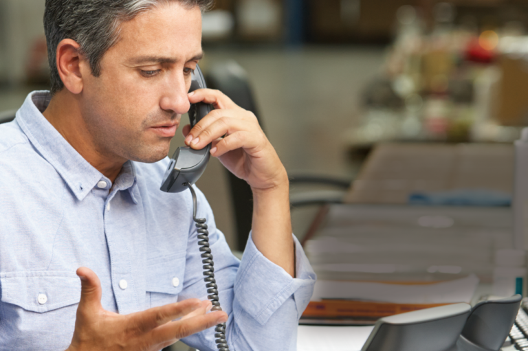 A person on the phone. Read about the best tips to avoid work comp missteps.