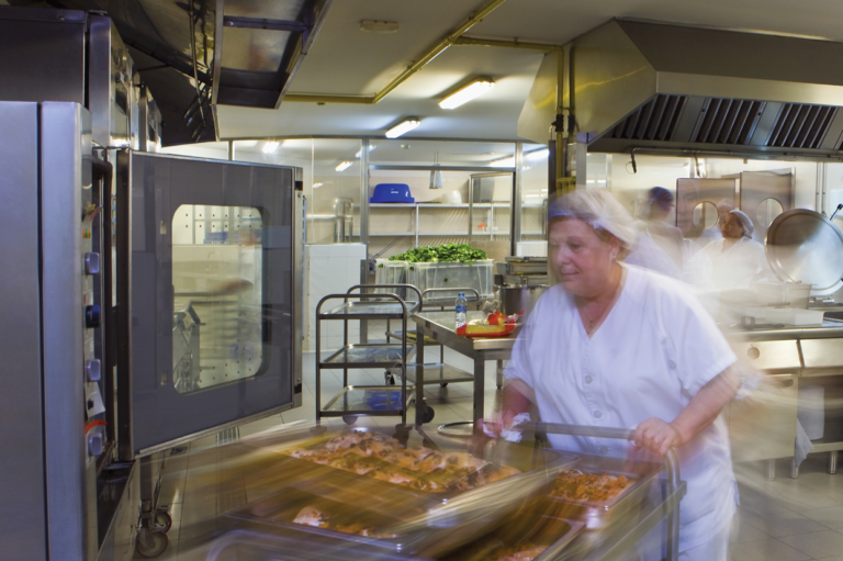 A person in a kitchen. Read about slip-resistant shoes to prevent falls in kitchen environments.