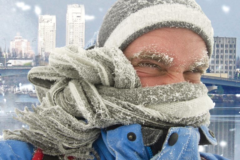 A person bundled up from the cold. Read about developing a workplace severe weather policy.