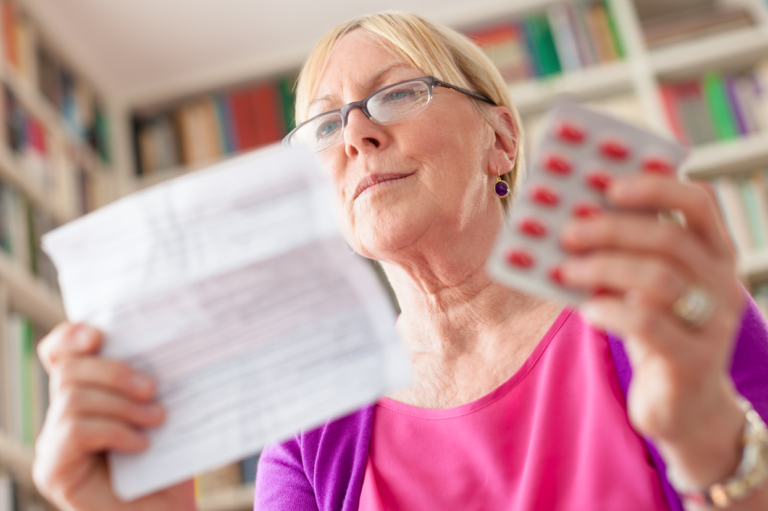 A woman holding pills and a piece of paper. Read about how opioid painkiller use can impact work comp claims.