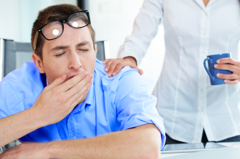 A worker yawning. Learn about fatigue and sleep deprivation in the workplace.