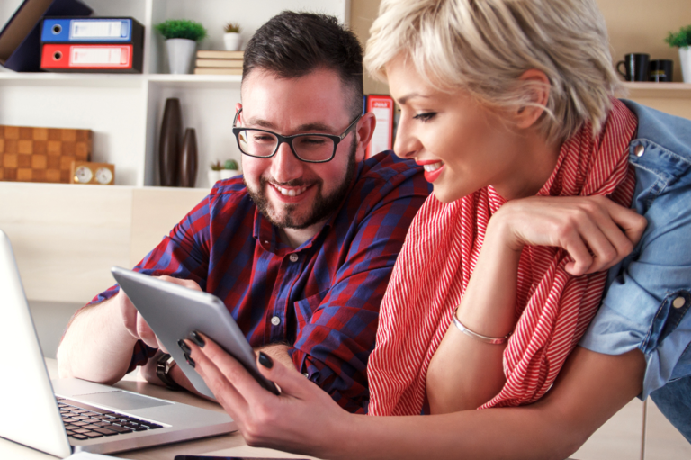 Employees looking at a tablet. Learn how your e-mod is calculated.