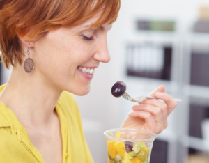 Worker eating a healthy snack of fruit as part of a successful employee wellness program
