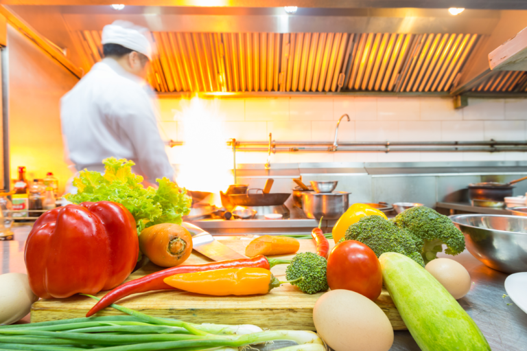 A chef in a kitchen. Learn about preventing and responding to burns in kitchen environments.