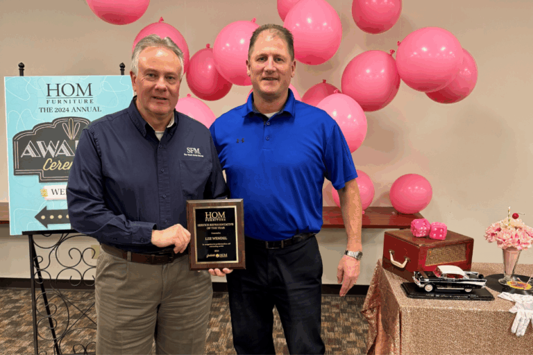 Dan Lentz (right), Safety Manager/HR Representative at HOM Furniture, presents Lee Wendel, Director of Loss Prevention at SFM, with the retailer’s Service Representative of the Year award